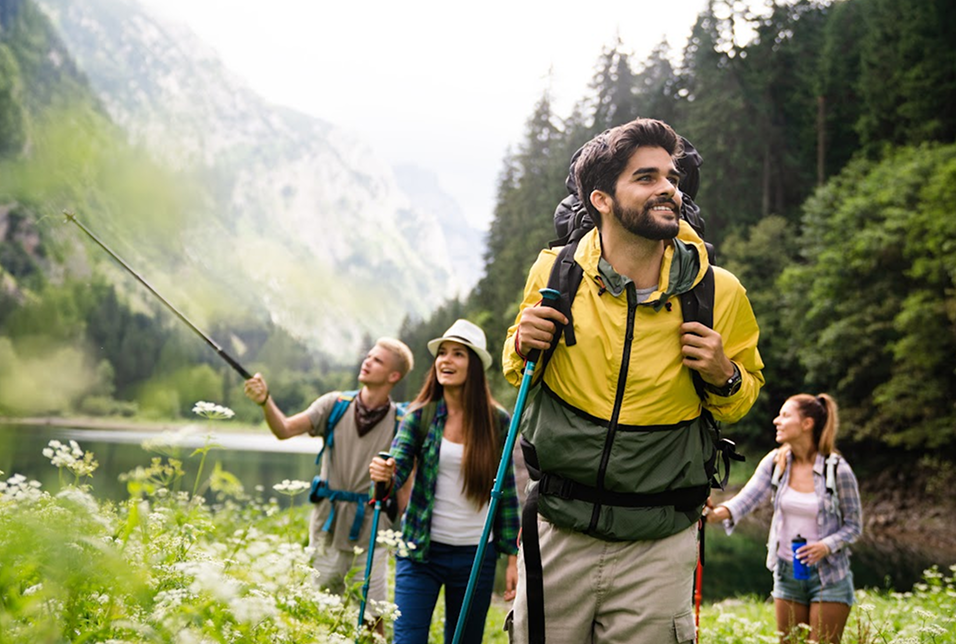 Group of friends hiking happily in a scenic mountain trail.